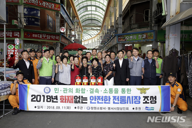 【창원=뉴시스】강경국 기자 = 12일 경남 창원시 의창구 명서시장에서 '말하는 소화기' 보급 캠페인이 진행된 가운데 박칠규 두산중공업 안전총괄담당 상무와 남성학 명서시장 상인회 회장, 이기오 창원소방서장 등 참석자들이 기념촬영을 하고 있다. 2018.09.12. (사진=두산중공업 제공)photo@newsis.com