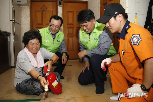  【창원=뉴시스】강경국 기자 = 12일 경남 창원시 성산구 웅남동 갯마을 홀몸 어르신 가구에서 두산중공업 안전나눔봉사단과 기술봉사단과 창원소방서 직원들이 소화기 사용법을 설명하고 있다. 2018.09.12. (사진=두산중공업 제공)photo@newsis.com