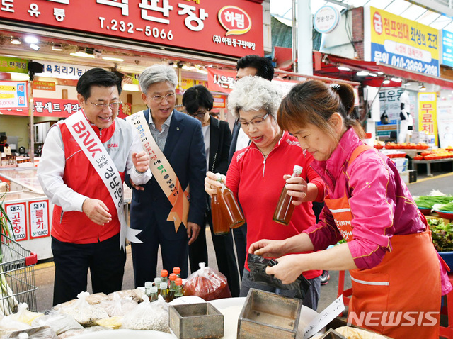 【창원=뉴시스】 홍정명 기자 = 14일 울산 동구 화정동 대송농수산물시장에서 BNK경남은행 김갑수(왼쪽) 상무가 '전통시장 활성화 캠페인' 일환으로 전통시장 온누리상품권으로 추석을 맞아 복지시설에 전달할 참기름 등 생필품을 사고 있다.2018.09.14.(사진=BNK경남은행 제공) photo@newsis.com