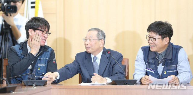 【서울=뉴시스】전진환 기자 = 14일 오전 서울 종로구 경제사회노동위원회 회의실에서 최종식 쌍용자동차 사장이 쌍용차 해고자 복직 잠정 합의안 발표 기자회견 중 김득중(왼쪽) 금속노조 쌍용자동차지부장의 손을 잡고 있다. 오른쪽은 홍봉석 쌍용자동차노조위원장. 2018.09.14. amin2@newsis.com