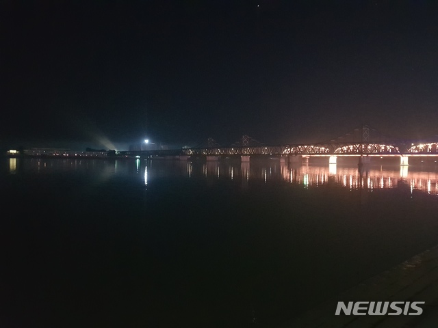 【단둥=뉴시스】김성진 기자 = 단둥에서 바라본 북한 신의주시의 밤 풍경. 상공으로 불빛을 비추는 모습이 목격됐다. 하얗게 불이 들어온 곳은 아파트나 호텔로 추정되는 고층건물 건설현장의 조명에서 나온 불빛이다. 2018.09.16. ksj87@newsis.com 