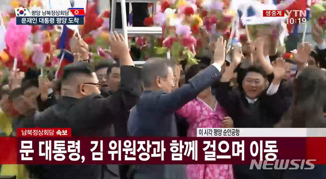【서울=뉴시스】 문재인 대통령과 김정은 북한 국무위원장이 18일 평양 순안공항에서 환영 나온 북한 주민들에 인사하고 있다. 2018.09.18. (사진=YTN 캡쳐) photo@newsis.com