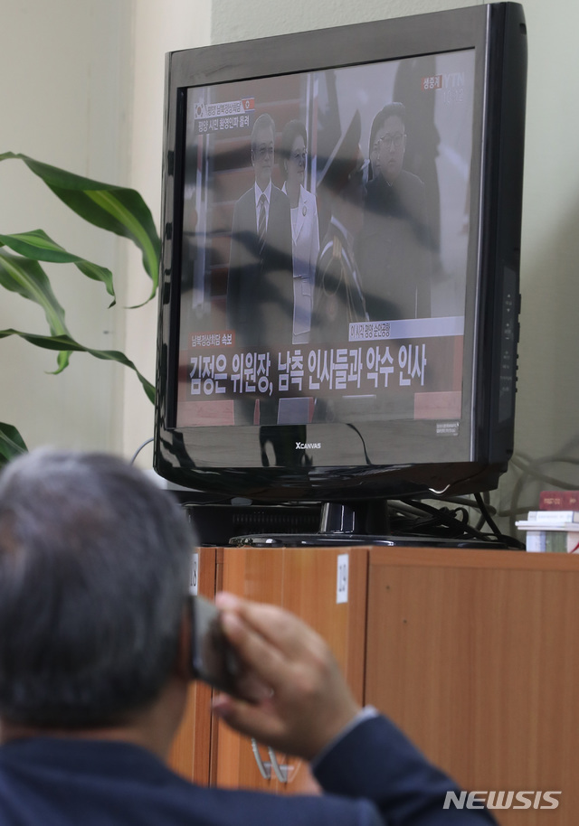 고【서울=뉴시스】전진환 기자 = 18일 오전 서울 여의도 개성공단기업협회에서 협회 관계자들이 제3차 남북정상회담을 위해 평양에 도착한 문재인 대통령과 영접하는 김정은 북한 국무위원장의 모습이 나오는 TV중계를 시청하며 누군가와 통화를 하 있다. 2018.09.18. amin2@newsis.com