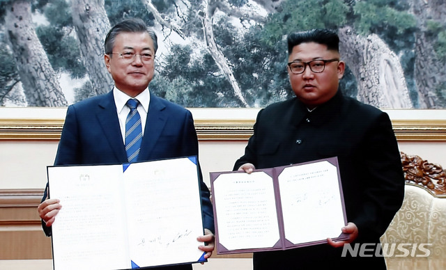 【남북정상회담 프레스센터(서울)=뉴시스】최동준 기자 = 19일 서울 동대문디자인플라자(DDP)에 차려진 남북정상회담 서울 프레스센터 대형 화면에 문재인 대통령과 김정은 위원장의 합의문 서명 뒤 기념촬영 하는 장면이 중계되고 있다. 2018.09.19.&nbsp; photocdj@newsis.com