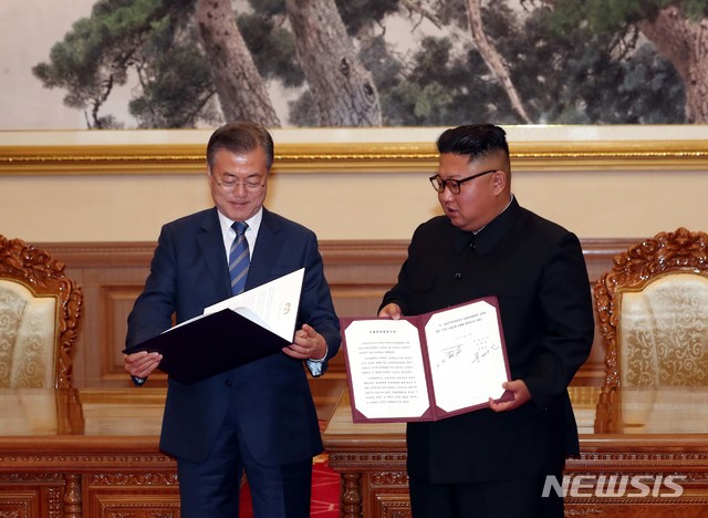 【평양=뉴시스】평양사진공동취재단 박진희 기자 = 문재인 대통령과 김정은 국무위원장이 19일 평양 백화원 영빈관에서 정상회담을 마친 뒤 평양공동선언서에 서명한 뒤 펼쳐 보이고 있다. 2018.09.19. photo@newsis.com