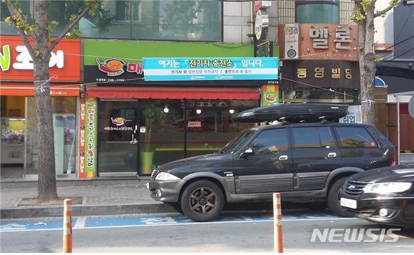 【대구=뉴시스】 대구시는 21일 오전 전기자동차 충전구역에 일반차량 주정차와 물건을 쌓는 등의 행위에 대해 단속에 나설 예정이라고 밝혔다. 전기자동차 충전구역에 알림현수막이 걸려있지만 일반자동차가 불법 주차를 하고 있다. 2018.09.20.(사진=대구시 제공) photo@newsis.com