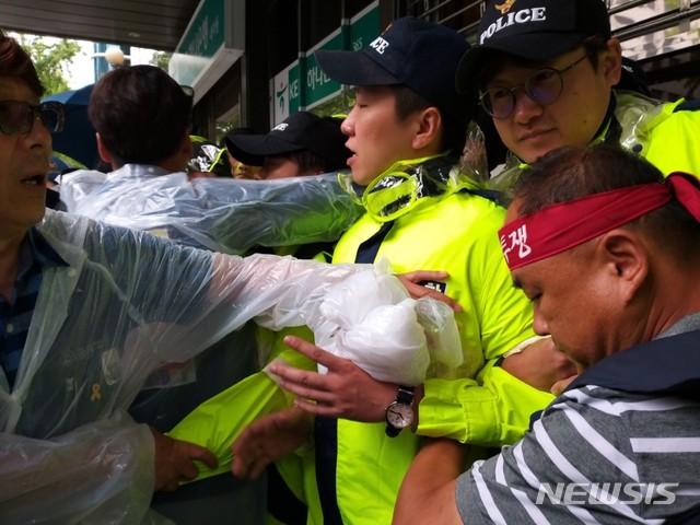 【서울=뉴시스】박민기 기자 = 20일 오전 서울 종로구에 있는 김앤장 법률사무소 건물 앞에서 전국금속노동조합 한국지엠지부 관계자들이 '법인분리 결사반대' 서명지 전달을 위해 진입을 시도하며 서울지방경찰청 소속 기동대원들과 몸싸움을 벌이고 있다. 2018.09.20. minki@newsis.com