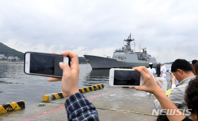 【창원=뉴시스】차용현 기자 = 20일 오전 서아프리카 가나해역에서 우리나라 및 외국선박의 호송작전 등을 무사히 수행하고 경남 진해군항으로 귀항하는 청해부대 26진 대원들의 가족들이 입항하는 문무대왕함을 스마트폰에 담고 있다. 2018.09.20. con@newsis.com