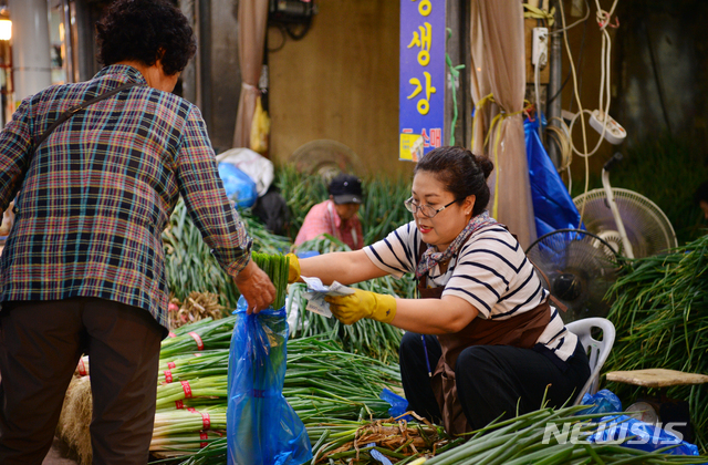 【광주=뉴시스】변재훈 기자 = 추석을 나흘 앞둔 20일 오후 광주 서구 양동시장 수산물가게에서 상인이 손님에게 대파를 건네고 있다. 2018.09.20.wisdom21@newsis.com