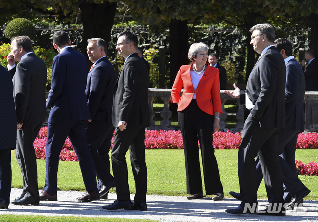 【잘즈부르크=AP/뉴시스】 영국의 테리사 메이 총리가 20일 비공식 EU 정상회의 마지막날 단체 사진 촬영장으로 이동하면서 다른 정상들과 섞이지 않고 홀로 서서 뒤의 누군가를 바라보고 있다. 내년 3월 영국은 EU를 떠난다. 2018. 9. 20.
