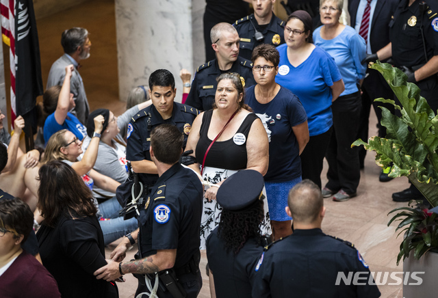  【워싱턴=AP/뉴시스】브렛 캐버노 미 대법관 지명자에 반대하는 시위대가 20일(현지시간) 척 그래슬리 상원 법사위원장의 사무실 앞에서 항의 시위를 벌이다 의회 경찰들에게 체포되고 있다. 캐버노가 고등학생 시절 자신을 성폭행하려 했다고 폭로한 크리스틴 블레이시 포드는 오는 27일 법사위 증언을 희망하며 그 자리에 캐버노는 참석하지 않기를 바란다고 포드의 변호사 데브라 캇츠가 법사위에 통보했다. 2018.9.21 