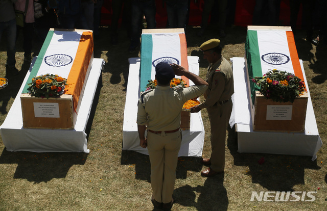 【스리나가르(카슈미르)=AP/뉴시스】인도 경찰들이 21일 인도령 카슈미르 스리나가르 남부 소피안에서 살해된 채 발견된 경찰 3명의 시신이 담긴 관 앞에서 거수경례와 헌화를 하고 있다. 카슈미르 지역은 파키스탄과 인도의 영유권 분쟁 지역으로, 이들 경찰은 파키스탄 무장단체에 납치됐다 살해된 것으로 추정되고 있다. 2018.09.22.