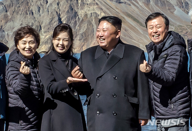 【백두산=뉴시스】평양사진공동취재단 박진희 기자 = 20일 백두산 천지에서 김정은 위원장 내외가&nbsp; 남쪽 수행원들과 기념사진을 찍고 있다. 처음에는 손을 내리고 있었으나, 강경화 외교부 장관으로부터 "남쪽에서 유행하는 손가락 하트를 해보자"는 제안을 받고, 따라하고 있다. 리설주 여사는 김 위원장의 손을 받치고 있다. 2018.09.23. (사진=청와대 제공) photo@newsis.com