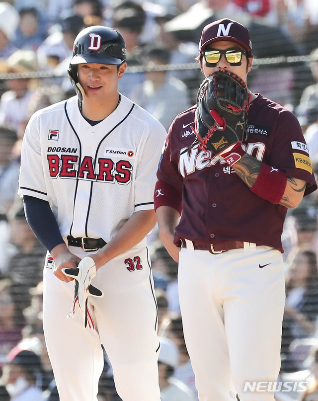 【서울=뉴시스】최진석 기자 = 25일 오후 서울 송파구 잠실야구장에서 열린 2018 KBO리그 넥센 히어로즈와 두산 베어스의 경기. 5회말 2사 주자없는 상황 김재환이 안타를 치고 1루에 진루 뒤 박병호의 발언에 미소짓고 있다. 2018.09.25. myjs@newsis.com