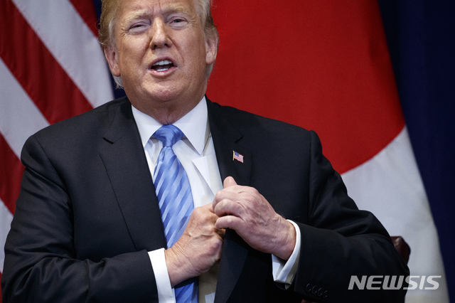 【뉴욕=AP/뉴시스】도널드 트럼프 미국 대통령이 지난9월26일(현지시간) 롯테뉴욕팰리스 호텔에서 아베 신조 일본 총리와 회담 중 양복 주머니에서 김정은으로부터 받은 편지를 꺼내 보여줬다가 다시 넣고 있다. 2018.11.13