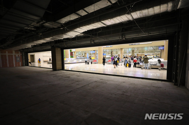 【인천공항=뉴시스】배훈식 기자 = 정부가 공항 입국장 면세점 도입키로한 27일 오후 인천국제공항 제1터미널 입국장 면세점 예정부스 앞에서 여행객들이 짐을 찾고 있다. 2018.09.27. dahora83@newsis.com
