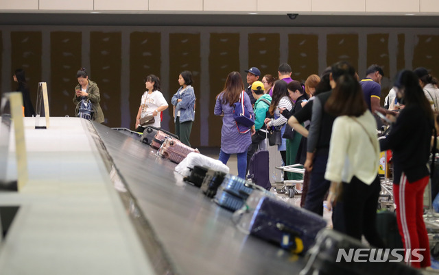 【인천공항=뉴시스】배훈식 기자 = 정부가 공항 입국장 면세점 도입키로한 27일 오후 인천국제공항 제1터미널 입국장 면세점 예정부스 앞에서 여행객들이 짐을 찾고 있다. 2018.09.27. dahora83@newsis.com