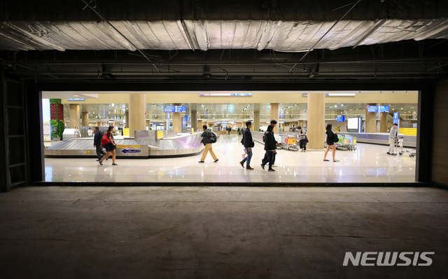 【인천공항=뉴시스】배훈식 기자 = 정부가 공항 입국장 면세점 내년부터 도입키로한 27일 오후 인천국제공항 제1터미널 입국장 면세점 예정부스 앞을 여행객들이 지나가고 있다. 2018.09.27. dahora83@newsis.com