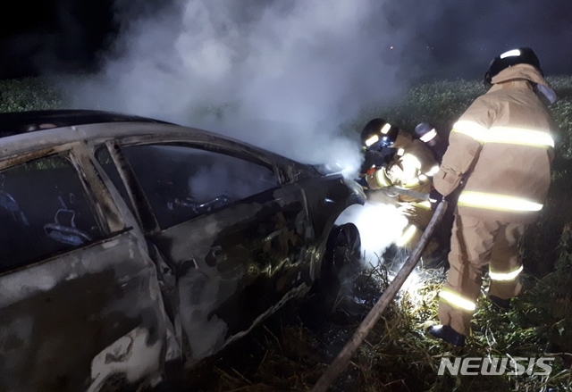 【제주=뉴시스】우장호 기자 = 지난 27일 오후 7시27분께 서귀포시 안덕면 동광리 인근 메밀밭에서 승용차에 불이 났다는 신고가 119에 접수됐다. 출동한 119 소방대원이 불을 끄고 있다. 2018.09.28. (사진=제주 서부소방서 제공) woo1223@newsis.com