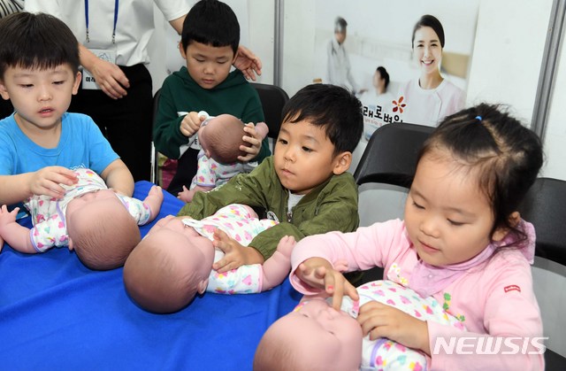 【부산=뉴시스】하경민 기자 = 신생아 돌보기 체험하는 어린이들. 이 사진은 기사와 직접적인 관련 없음.