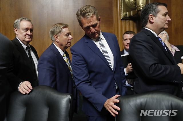 【워싱턴=AP/뉴시스】미 상원 법사위원회의 제프 플레이크 의원(가운데)이 28일 브렛 캐버노 대법관 지명자에 대한 인준안 표결을 마친 뒤 법사위를 빠져나가고 있다. 법사위는 이날 11대 10으로 인준안을 통과시켜 상원 전체회의에 회부했다. 법사위는 그러나 캐버노의 배경에 대한 보강 조사를 도널드 트럼프 대통령에게 요구하는 한편 연방수사국(FBI)의 조사를 위해 상원 전체회의의 표결을 연기하기로 했다. 2018.9.29