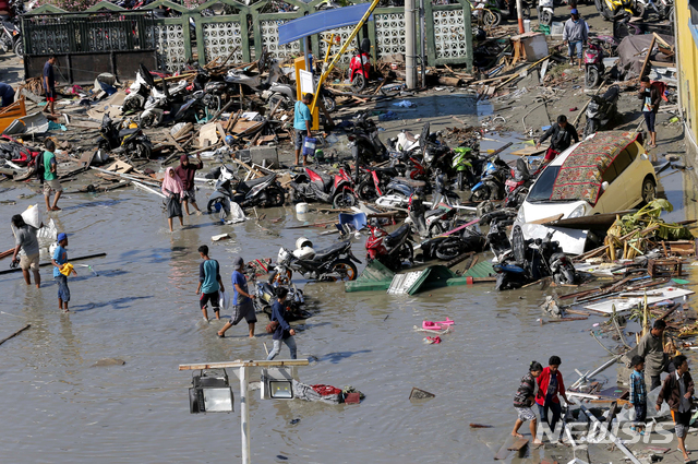 【팔루(인도네시아)=AP/뉴시스】 30일(현지시간) 인도네시아 팔루 지역에서 지진 피해를 입은 주민들이 쇼핑몰 주변을 탐색하고 있다. 2018.10.01 