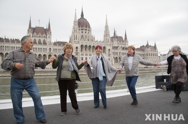 【부다페스트( 헝가리)= AP/뉴시스】 유엔이 제정한 "세계 노인의 날"인 1일 부다페스트의 선착장에서 다뉴브유람선을 기다리는 노인들이 함께 춤추며 즐기고 있다. 그리스는 노인 차별 없는 사회를 위한 캠페인을 벌이며 유럽 제3의 저출산국가라는 통계를 발표했다.