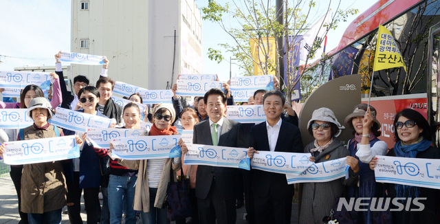 【전주=뉴시스】김얼 기자= 대한민국 테마여행 10선 광역투어버스 발대식 및 시승식이 4일 전북 전주시 전주역 첫마중길에서 실시된 가운데 김승수 전주시장을 비롯한 문화해설가 및 관계자들이 손피켓을 들고 구호를 외치고 있다. 2018.10.04pmkeul@newsis.com