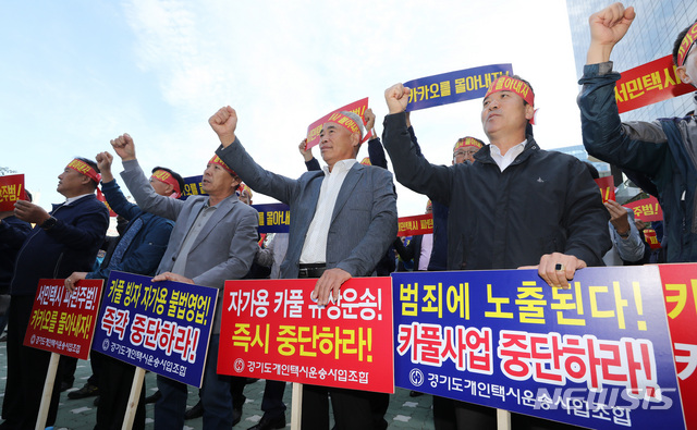 【성남=뉴시스】이영환 기자 = 전국택시운송사업조합연합회, 전국개인택시운송사업조합연합회, 전국택시노동조합연맹, 전국민주택시노동조합연맹 4개 단체로 구성된 불법 카풀 관련 비상대책위원회&nbsp; 관계자들이 4일 오전 경기도 성남시 판교 카카오모빌리티 사옥 앞에서 IT 기업 카카오의 카풀서비스를 반대하며 집회를 열고 구호를 외치고 있다. 2018.10.04. 20hwan@newsis.com