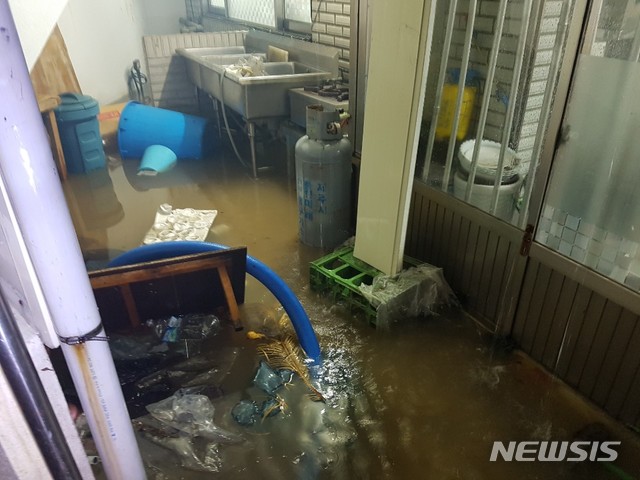 【제주=뉴시스】배상철 기자 = 폭우를 동반한 제25호 태풍 '콩레이'가 근접하고 있는 5일 오후 제주시 애월읍 수산리에 한 주택이 침수 피해를 입어 소방대원들이 물을 빼내고 있다. 2018.10.05. (사진=제주소방본부 제공)bsc@newsis.com