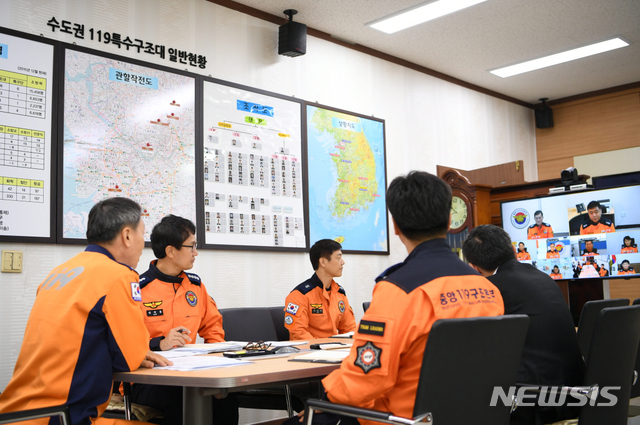 【서울=뉴시스】조종묵(왼쪽) 소방청장이 5일 오전 태풍 콩레이 북상으로 태풍이동경로에 따라 선제적 조치에 나선 경기도 남양주시 중앙119구조본부수도권 119특수구조대를 방문해 전국 10개 특수구조대장들과 영상을 통해 현재 상황을 보고 받고 있다. 2018.10.05. (사진=소방청 제공) photo@newsis.com