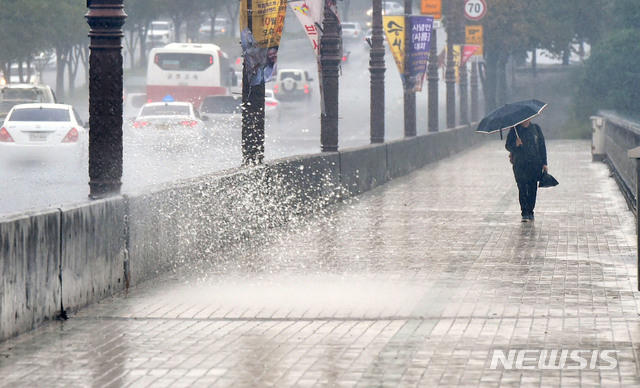 【대구=뉴시스】우종록 기자 = 북상하는 제25호 태풍 '콩레이'의 영향으로 비가 내리고 있는 5일 오후 대구 동구 방촌동 화랑교에서 우산을 쓴 시민이 비를 맞으며 발걸음을 재촉하고 있다. 2018.10.05. wjr@newsis.com
