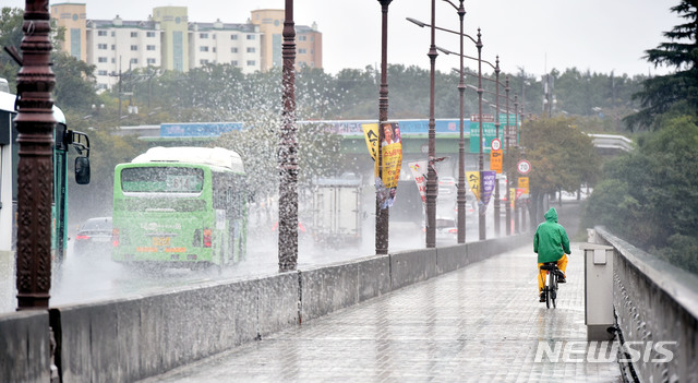 【대구=뉴시스】우종록 기자 = 북상하는 제25호 태풍 '콩레이'의 영향으로 비가 내리고 있는 5일 오후 대구 동구 방촌동 화랑교에서 우의 입은 한 시민이 비를 맞으며 자전거를 타고 있다. 2018.10.05.&nbsp; wjr@newsis.com 