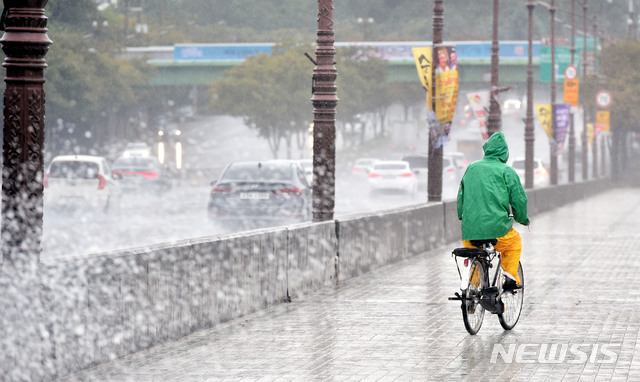 【대구=뉴시스】우종록 기자 = 북상하는 제25호 태풍 '콩레이'의 영향으로 비가 내리고 있는 5일 오후 대구 동구 방촌동 화랑교에서 우의 입은 한 시민이 비를 맞으며 자전거를 타고 있다. 2018.10.05.&nbsp; wjr@newsis.com 
