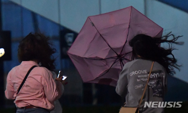 【부산=뉴시스】 하경민 기자= 지난 5일 오후 부산 해운대구의 한 길거리에서 퇴근길에 오른 시민들이 비바람이 몰아치자 우산을 쓴 채 힘겹게 걸어가고 있다. 2018.10.05.&nbsp; yulnetphoto@newsis.com