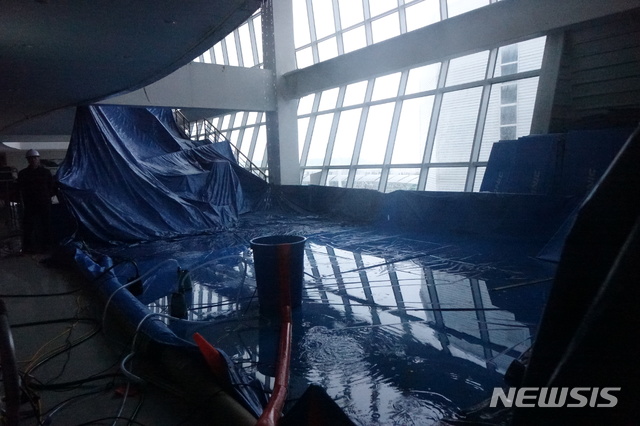 【제주=뉴시스】강정만 기자 = 태풍 '콩레이'의 영향으로 어르신들의 게이트볼장 등으로 이용되고 있는 제주복합체육관이 비가 새어 천막을 대고 물을 빼내는 응급조치를 하고 있다. 이 체육관은 지난 8월 제주도에 영향을 준 태풍 '솔릭'의 영향으로 천장 900㎡가 뜯겨져 나가 막 보수공사를 하려던 때였다. 2018.10.06&nbsp; kjm@newsis.com 