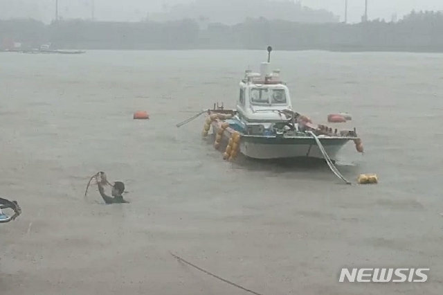 【남해=뉴시스】차용현 기자 = 6일 오전 경남 남해군 서상항에서 통영해경 소속 한 경찰관이 바다에 빠진 50대 남성을 구조하고 있다. 2018.10.06. (사진=통영해양경찰서 제공) photo@newsis.com