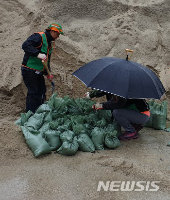 【강릉=뉴시스】김경목 기자 = 강원 강릉시청 공무원들이 지난 5일 제25호 태풍 '콩레이(KONG-REY)'로 인한 침수 피해를 최소화하기 위해 모래주머니를 만들고 있다. 2018.10.06. (사진=강릉시청 제공) photo@newsis.com