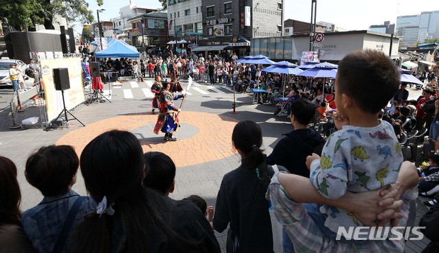 【서울=뉴시스】전신 기자 = 7일 서울 종로구 북촌로5길 일대에서 시민들과 외국인 관광객들이 무예도보통지 24반 무예 공연을 관람하고 있다. 서울시는 이날 오전 10시부터 오후 7시까지 국립현대미술관~아트선재센터~정독도서관입구~송원아트센터~윤보선길진입로~재동초등학교삼거리에 이르는 북촌로5길 430m 구간을 '차 없는 거리'로 첫 시범 운영한다고 밝혔다. 2018.10.07. photo1006@newsis.com