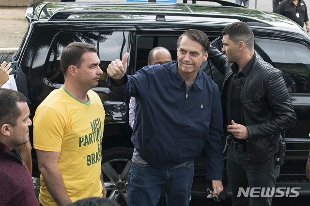 【리우데자네이루=AP/뉴시스】 7일(현지시간) 극우 성향인 사회자유당(PSL) 자이르 보우소나루 대통령 후보(가운데)가 투표를 하기 위해 리우데자네이루에 위치한 투표소에 도착해 엄지손가락을 치켜 올려 보이고 있다. 2018.10.08.