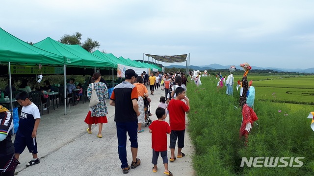 【창원=뉴시스】강경국 기자 = 지난달 7일부터 3일간 경남 창원시 의창구 동읍 무점마을에서 열린 코스모스 축제장에 시민과 관광객들이 행사장 한켠에 설치한 허수아비를 구경하고 있다. 2018.10.08. (사진=창원시청 제공)photo@newsis.com