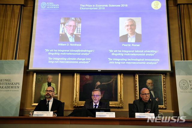 【스톡홀름=AP/뉴시스】스웨덴 왕립과학원 노벨위원회가 8일(현지시간) 열린 기자회견에서 노벨 경제학상 수상자들인 윌리엄 노드하우스 예일대 교수(77)와 폴 로머 뉴욕대 교수(62)를 화면에 띄우고 있다. 노드하우스 교수는 기후변화의 경제적 효과에 관한 연구로, 로머 교수는 내생적 성장이론을 도입한 공로를 인정받아 노벨 경제학상을 수상했다. 