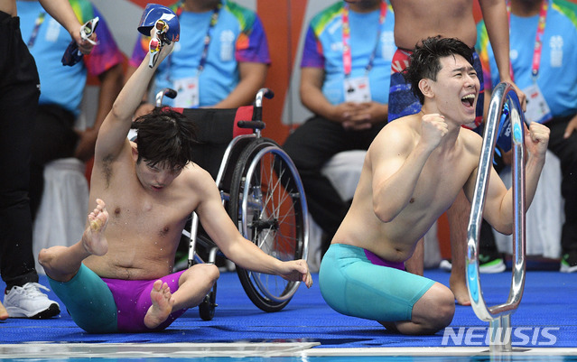 【자카르타(인도네시아)=뉴시스】 사진공동취재단 = '2018 인도네시아 장애인아시아경기대회' 수영 남북 단일팀이 은빛 물살을 갈랐다. 8일 오후(현지시간) 인도네시아 자카르타 겔로라 붕 카르노(GBK) 아쿠아틱센터에서 열린 수영 계영 34P(1x100) 결승 경기. 남북 단일팀 선수들이 일본의 실격으로 은메달이 확정되자 환호하고 있다. 남북 단일팀이 장애인 국제대회에서 메달을 획득한 것은 이번이 처음이다. 2018.10.08. photo@newsis.com