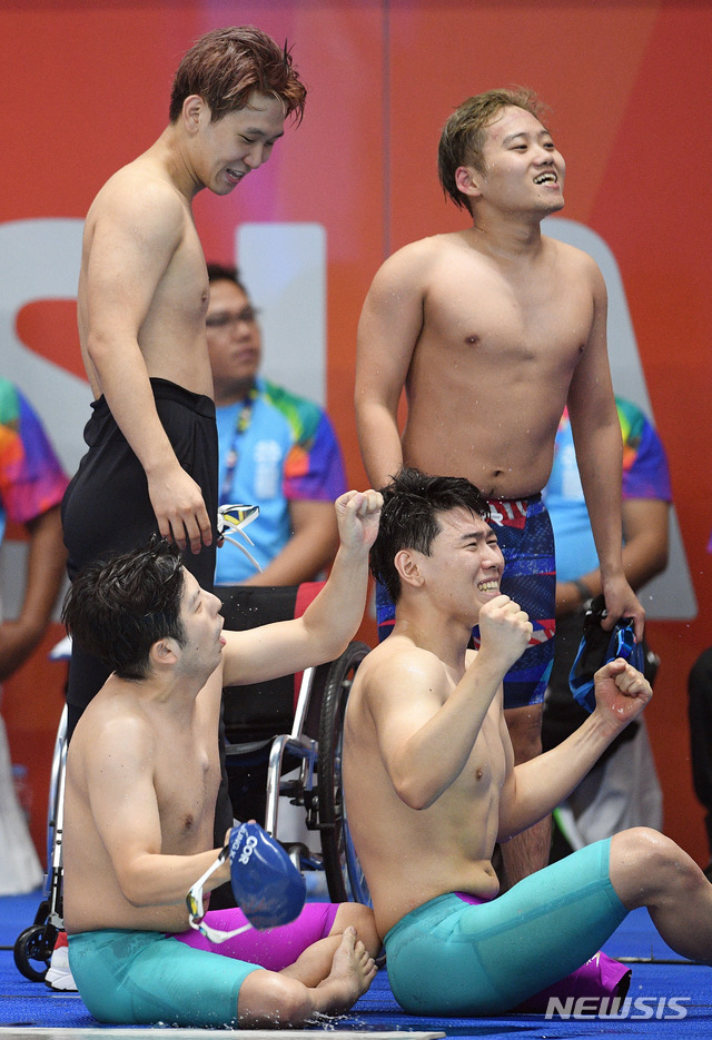 【자카르타(인도네시아)=뉴시스】 사진공동취재단 = '2018 인도네시아 장애인아시아경기대회' 수영 남북 단일팀이 은빛 물살을 갈랐다. 8일 오후(현지시간) 인도네시아 자카르타 겔로라 붕 카르노(GBK) 아쿠아틱센터에서 열린 수영 계영 34P(1x100) 결승 경기. 남북 단일팀 선수들이 일본의 실격으로 은메달이 확정되자 환호하고 있다. 남북 단일팀이 장애인 국제대회에서 메달을 획득한 것은 이번이 처음이다. 2018.10.08. photo@newsis.com