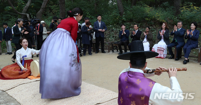 【여주=뉴시스】박진희 기자 = 문재인 대통령과 부인 김정숙 여사가 한글날을 맞아 9일 오후 경기 여주시 세종대왕 유적지를 찾아 영릉(효종)을 참배한 뒤 왕의 숲길을 따라 세종대왕릉으로 걷던 중 숲길에서 열린 연주팀 '여민'의 창작판소리 공연 '훈민정음 창제'를 관람하고 있다. 2018.10.09.&nbsp; pak7130@newsis.com 