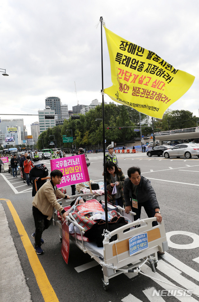 【서울=뉴시스】박주성 기자 = 고위험희귀난치근육장애인생존권보장연대 등 장애인 단체들이 10일 오후 서울 덕수궁에서 청와대 분수대까지 샤우팅 온 더 베드(침대에서 부르짖는 절박한 외침) 퍼레이드 캠페인을 진행하고 있다. 2018.10.10. park7691@newsis.com