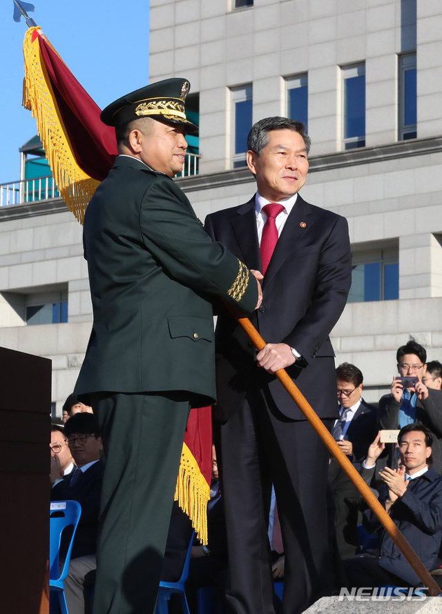 【서울=뉴시스】이영환 기자 = 정경두 국방부 장관이 11일 오전 서울 용산구 국방부 대연병장에서 열린 제41대 합참의장 취임식에서 박한기 합참의장에게 부대기를 수여하고 있다. 2018.10.11.&nbsp; 20hwan@newsis.com