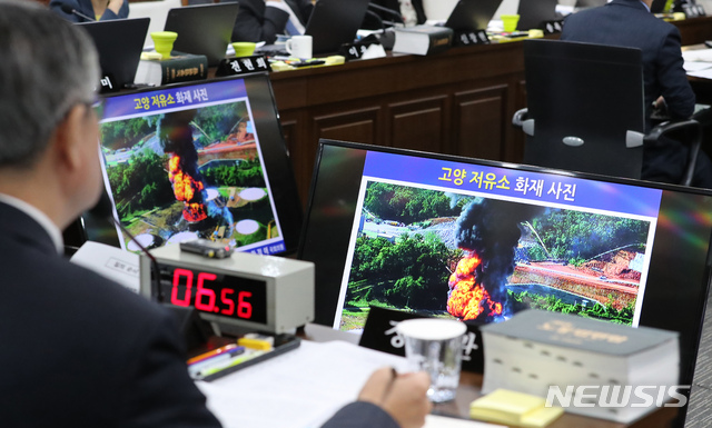 【세종=뉴시스】강종민 기자 = 11일 정부세종청사에서 열린 국회 환경노동위원회의 고용노동부에 대한 국정감사에서 더불어민주당 한정애 위원이 준비한 고양 유류탱크 대형 화재 사진을 이재갑 장관이 살펴보고 있다. 2018.10.11. ppkjm@newsis.com