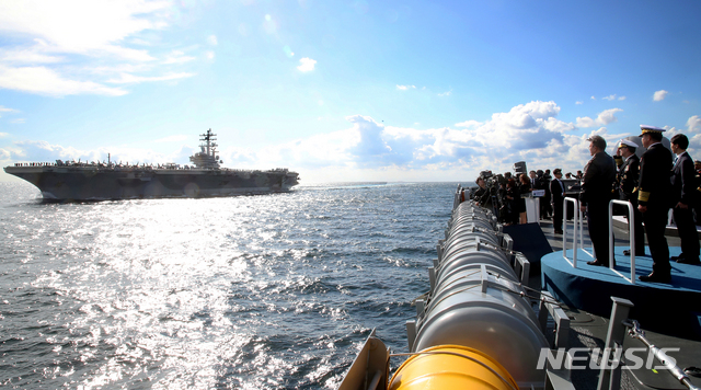 【서귀포=뉴시스】전신 기자 = 문재인 대통령이 11일 제주민군복합형 관광미항 일대에서 열린 2018 대한민국 해군 국제 관함식에 참석해 좌승함인 일출봉함에서 미국 핵추진 항공모함 로널드 레이건함의 해상사열을 하고 있다. 2018.10.11. photo1006@newsis.com