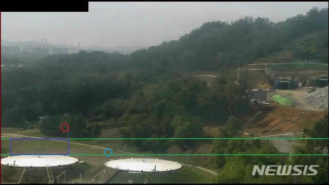 【고양=뉴시스】 이호진 기자 = (사진2) 붉은 원이 가로등 헤드 앞을 지나 떨어지고 있는 풍등. 파란 원이 실제 풍등과 크기가 비슷한 구조물. 사진 우측 하단의 남색 직사각형 안이 풍등의 진행 방향과 낙하 속도, 거리 등을 종합해 추정한 낙하 예상 위치다. 2018.10.12.&nbsp; asake@newsis.com 